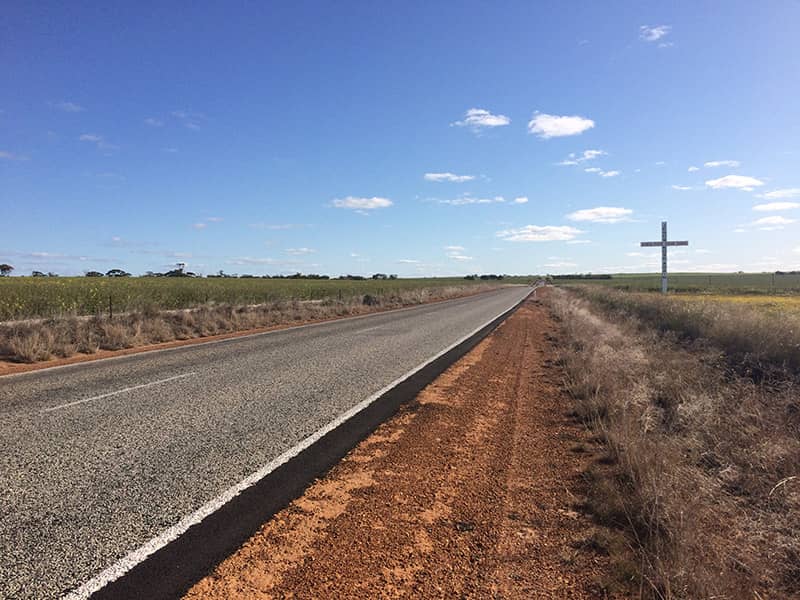 A large Jesus cross on the side of the road in a canola field in Dowerin, Western Australia