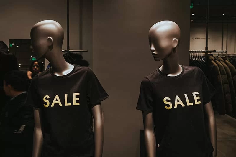 Two mannequins wearing black sale shirts