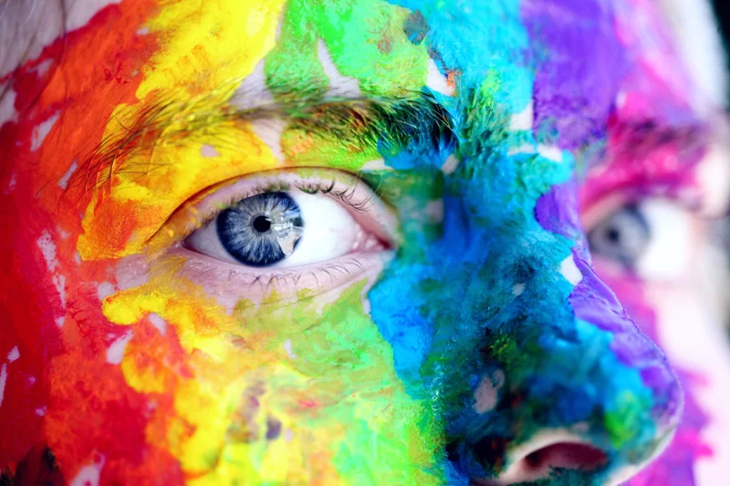A person with different coloured paint on their face