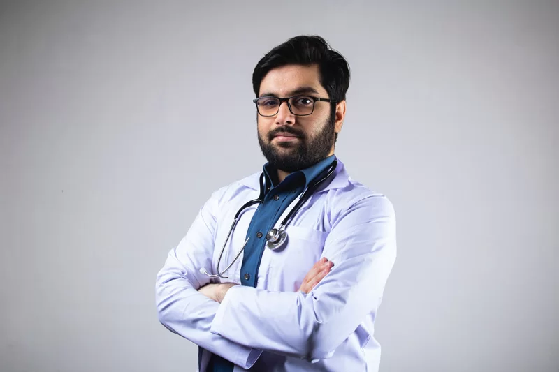 A doctor with his hands crossed for a photo for his website