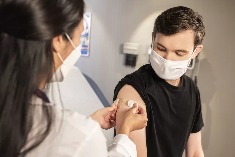 A man getting a needle by a nurse