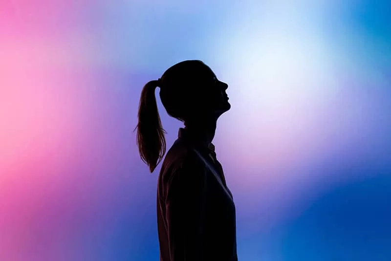 A girl silhouette on a pink and bluish background