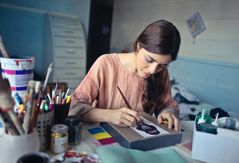 A logo designer working at her desk on a design for a client.