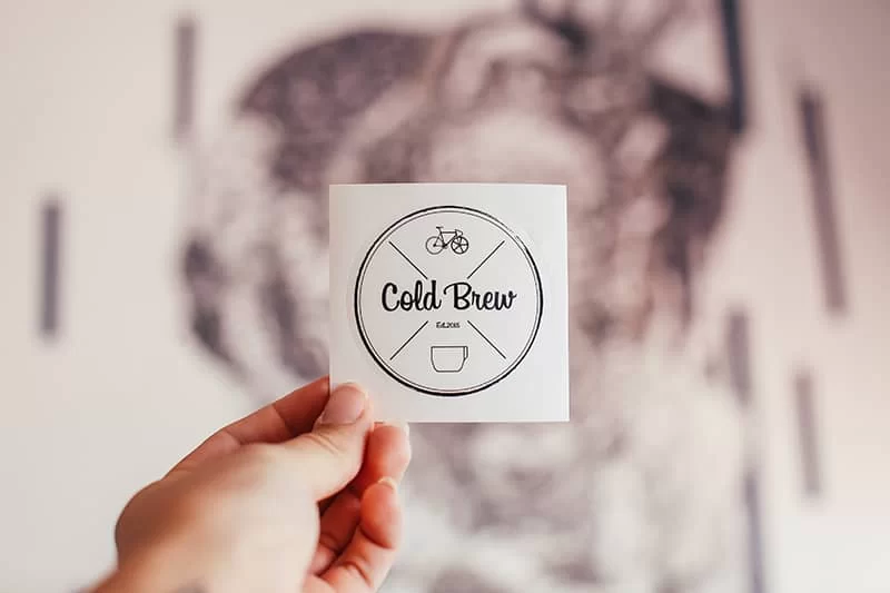 A beer coaster with a logo design that says "Cold Beer".