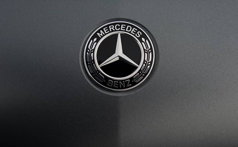 A Mercedes-Benz badge on a car.