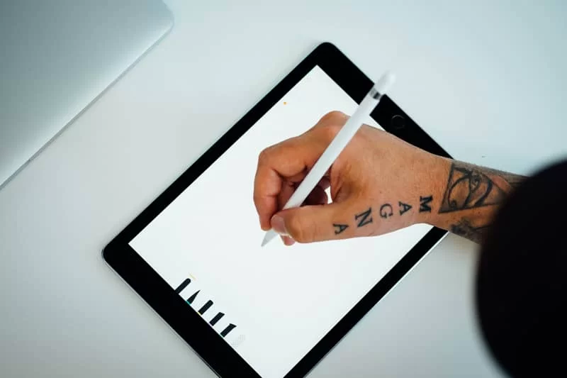 A logo designer using a tablet to create a logo design.